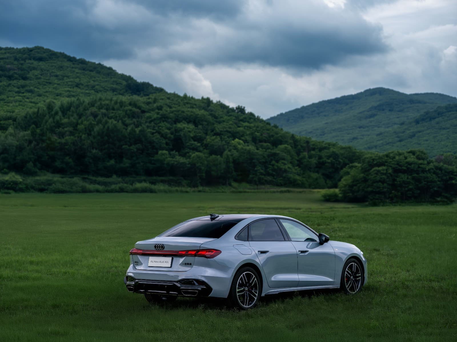 Серебристый седан Audi A5L на фоне гор